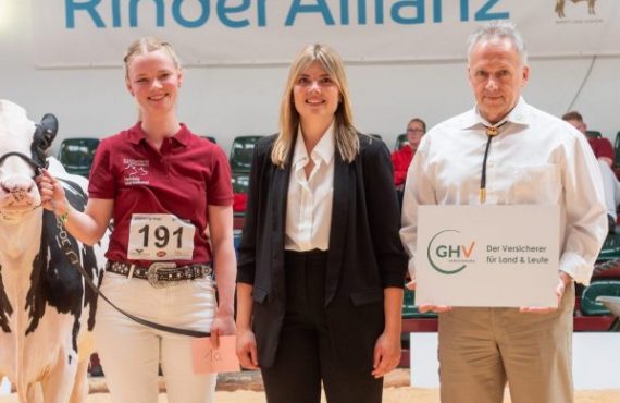 Drei Menschen bei einer Tierschau. Links, die Gewinnerin mit ausgezeichnetem Tier, rechts GHV- Mitarbeiter.